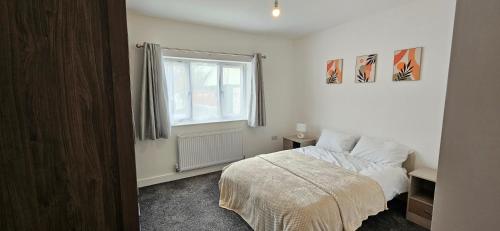 a white bedroom with a bed and a window at Citrine Suite - Sleeps 8 with Parking in Stoke on Trent