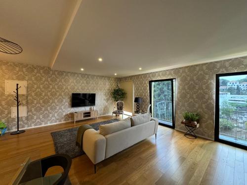 a living room with a couch and a tv at Carreira Residence in Funchal