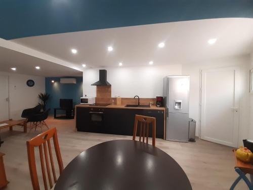 Il dispose d'une cuisine et d'un salon avec une table et un réfrigérateur. dans l'établissement Appartement 50m2 rez de chaussée en plein centre ville garage gratuit, à Valras-Plage