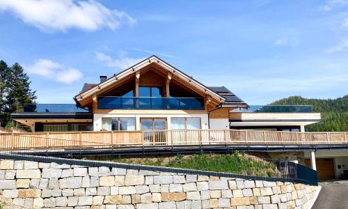 a house on a hill with a stone wall at Alpen Luxury Lodge, MARIAZELL - Adults only in Mariazell