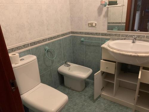 a bathroom with a toilet and a sink at Apartamento Portela in Bueu