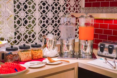 a kitchen counter with jars of food and orange juice at Hotel Midtown Ratsada in Phuket Town