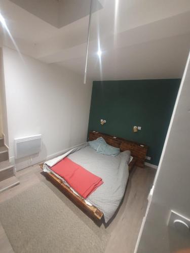 Cette petite chambre comprend un lit avec un mur vert. dans l'établissement Centre, à Morlaix