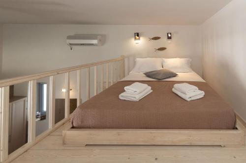 a bedroom with a bed with two towels on it at Oinoni's Home - ALEXANDROS studio in Souvala