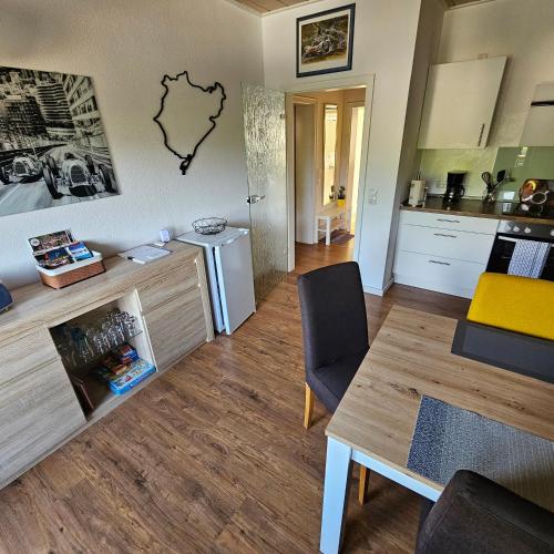 uma sala de estar com uma mesa e uma cozinha em Am Lindenbaum, Ferienwohnung in Siebenbach am Nürburgring em Siebenbach