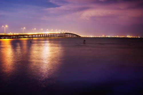 a bridge over a body of water at night at Oyster Drive Bungalow in Port Isabel