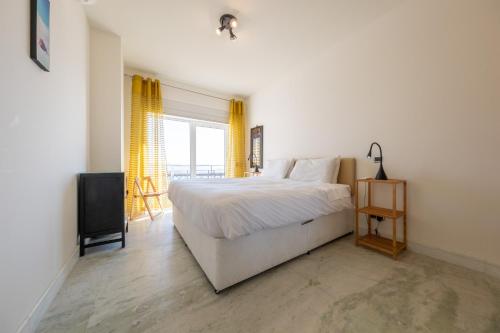 Schlafzimmer mit einem weißen Bett und einem TV in der Unterkunft Fábrica da Ribeira 80 by Destination Algarve in Lagos