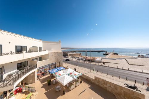einen Blick auf ein Gebäude mit Meerblick im Hintergrund in der Unterkunft Fábrica da Ribeira 80 by Destination Algarve in Lagos