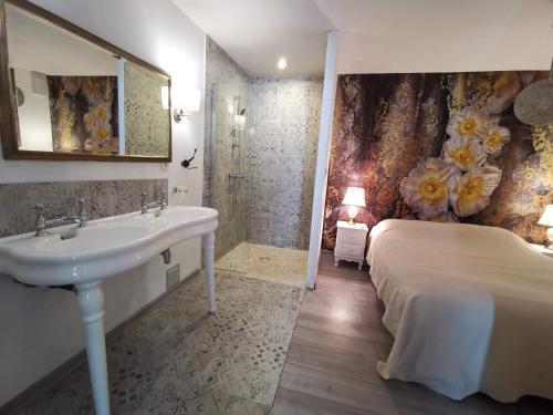 une salle de bain avec un lavabo et un lit dans l'établissement Magnifique Bastide 10 chambres, à Deaux