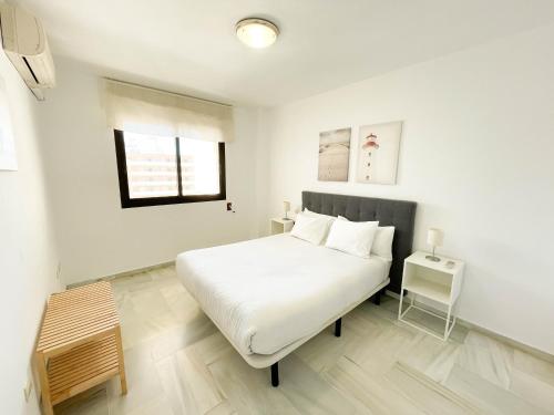 um quarto branco com uma cama e uma mesa em Montemar Terral Apartments em Torremolinos