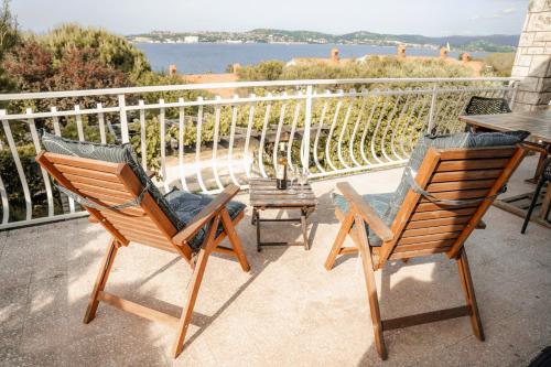 two chairs and a table on a balcony at Casa Monterosso - great sea view, free parking, large terrace, near the sea in Crveni Vrh