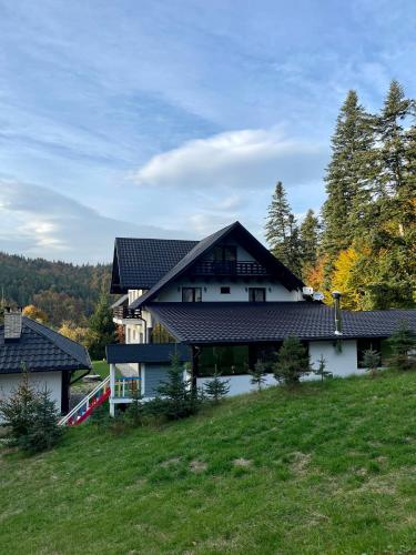 a large white house with a black roof at Casa Mălina Putna in Putnişoara