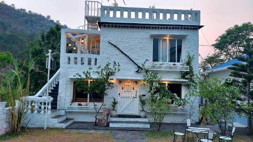 a white house with a staircase in front of it at DM Farms Morni Hills Panchkula in Morni