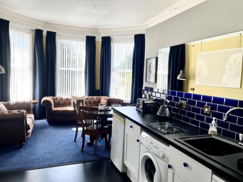 a kitchen and living room with a table and chairs at Atlantis Holiday Apartments in Torquay