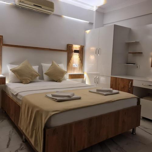 a bedroom with a large bed with two towels on it at ALİBABAM APART OTEL in Kuşadası