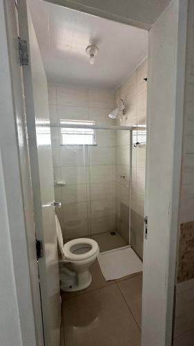 a bathroom with a toilet and a glass shower at Hotel Rota Dos Tropeiros in Castro
