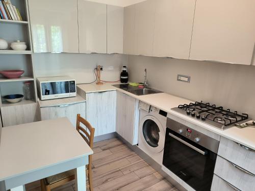 een keuken met een fornuis en een wasmachine bij CARLA' S HOUSE in Anzola dell'Emilia
