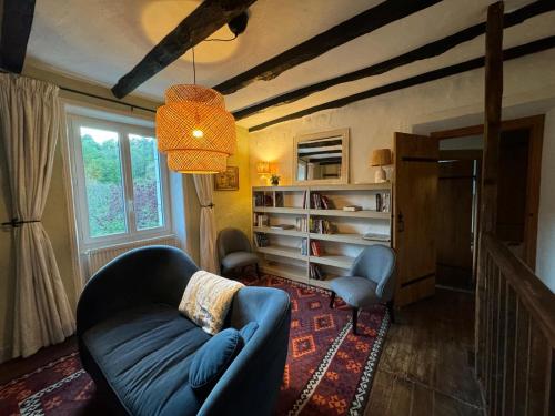 un salon avec un canapé bleu et une fenêtre dans l'établissement Cocorico, à Jumilhac-le-Grand