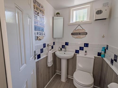 a small bathroom with a toilet and a sink at 3 Bed in Ventnor 89972 in Niton