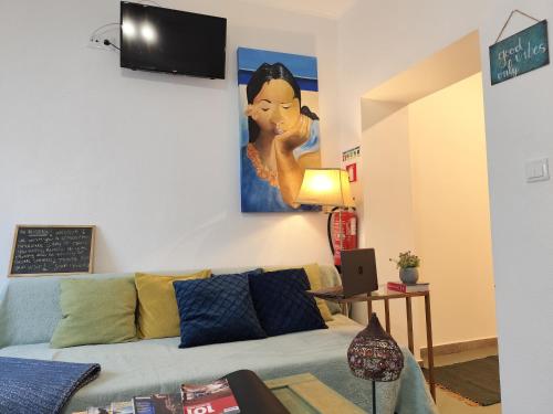 a living room with a couch and a painting on the wall at Stressfree Apartamento in Vila Nova de Milfontes