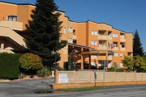 an apartment building with a fence in front of it at Hotel La Ruota in Pianfei