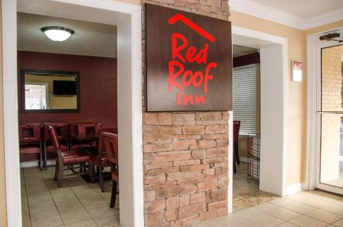 a restaurant with a red roof inn sign on a brick wall at Red Roof Inn Williamsburg in Williamsburg