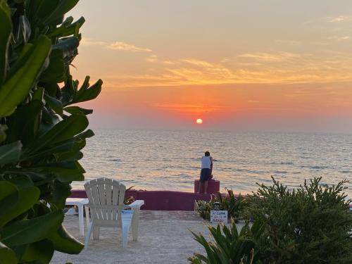 - une personne debout sur la plage pour observer le coucher du soleil dans l'établissement "Casitas Arcoiris" Excelente ubicación - Petfriendly, à Isla Mujeres