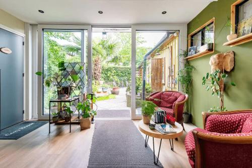 ナイメーヘンにあるCozy House - fietsverhuur, eigen keuken en badkamerの緑の壁のリビングルーム(赤い椅子付)