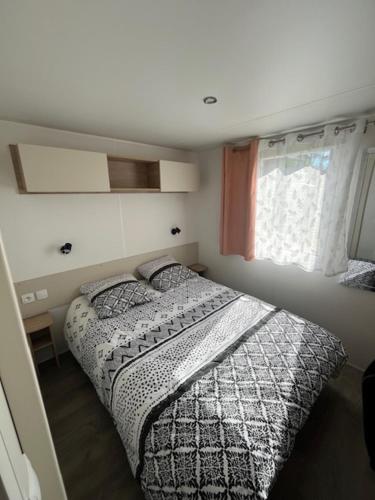 une petite chambre avec un lit et une fenêtre dans l'établissement Mobilhome dans camping siblu les Viviers, à Lège-Cap-Ferret