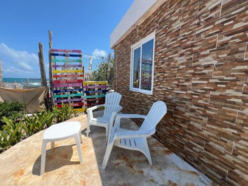 - 2 chaises blanches et une table sur la terrasse dans l'établissement "Casitas Arcoiris" Excelente ubicación - Petfriendly, à Isla Mujeres