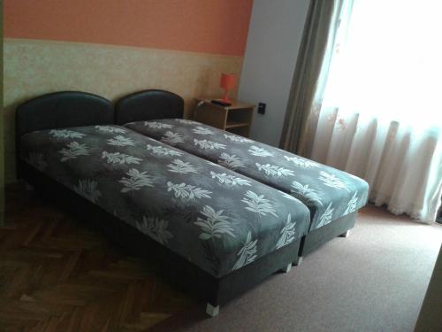 a bedroom with a bed with a blue blanket on it at Petra Vendégház in Bük