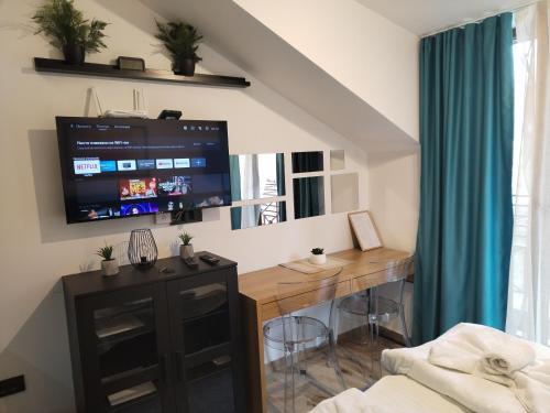 een kamer met een bureau en een tv aan de muur bij N Lux 95 Milmari in Kopaonik
