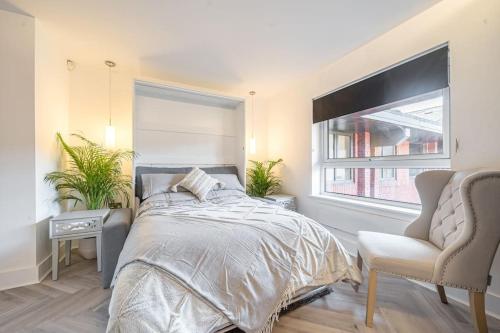 a bedroom with a bed and a chair and a window at Anchor in Basingstoke