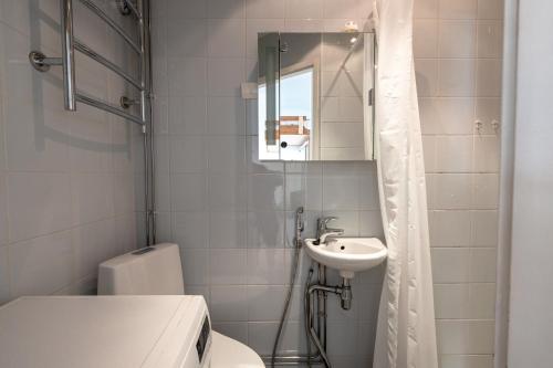 ein Badezimmer mit einem WC, einem Waschbecken und einem Spiegel in der Unterkunft 2ndhomes Kamppi Apartments 1 in Helsinki