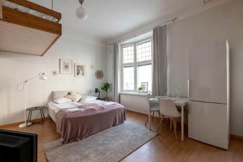 Schlafzimmer mit einem Bett, einem Tisch und einem Kühlschrank in der Unterkunft 2ndhomes Kamppi Apartments 1 in Helsinki