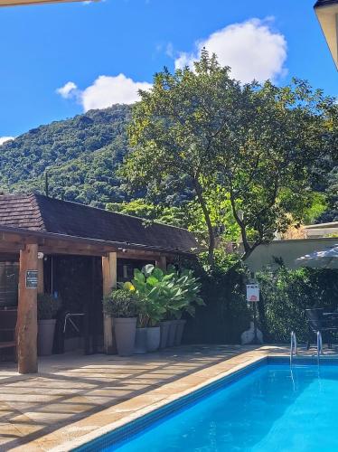 a swimming pool in front of a house with a mountain at Granja Brasil puc 10 2 in Petrópolis