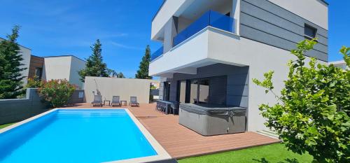 a house with a swimming pool in front of it at Villa Primavera in Novalja