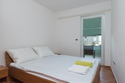 a bedroom with a bed with a yellow towel on it at Apartments Riva in Medulin