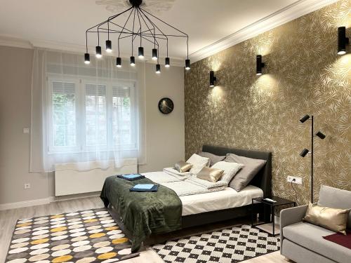 a bedroom with a bed and a couch and a chandelier at Buda Castle Serpentine Apartments in Budapest
