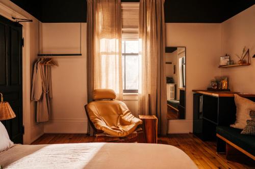 Habitación con silla, cama y ventana en Somewhere Inn Collingwood, en Collingwood
