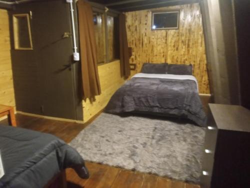 ein Schlafzimmer mit zwei Betten und einem Teppich in der Unterkunft Cabaña Trapecio in San Carlos de Bariloche