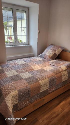 une chambre avec un lit avec une couette dessus dans l'établissement Maison avec 3 chambres parentales, à Plouénan