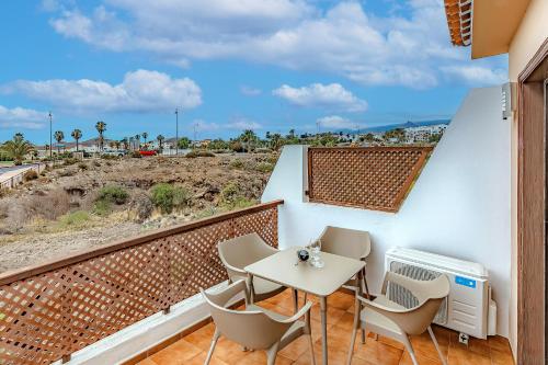 a balcony with a table and chairs and the beach at Ocean View Apartment in Albatros Golf del Sur in San Miguel de Abona
