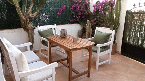 una mesa de madera y sillas en un patio con flores en Apartamento limonero, en Albox