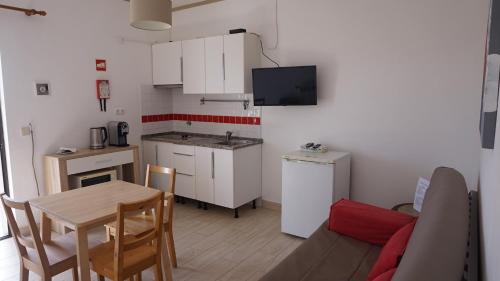 a living room with a kitchen and a table with a table at Apartamentos na Quinta Altavista do Carvalhal in Zambujeira do Mar