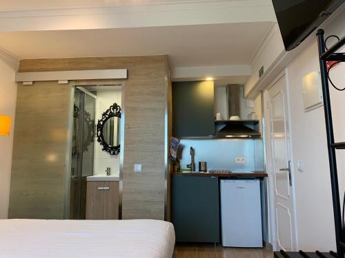 a room with a bed and a small kitchen at Discovery Apartment Carnaxide in Carnaxide