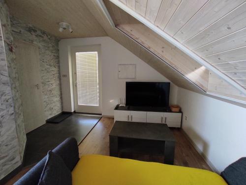 a living room with a couch and a tv at Apartmán Čeložnice in Čeložnice