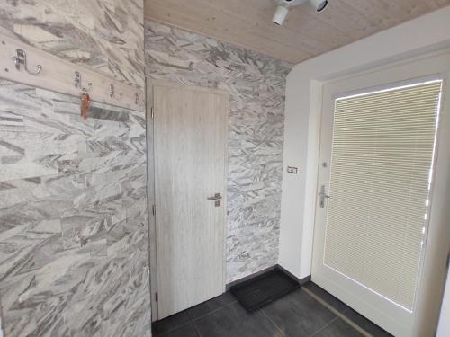 a hallway with a door and a stone wall at Apartmán Čeložnice in Čeložnice