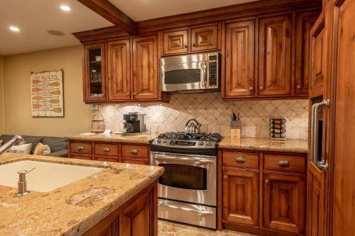 a kitchen with wooden cabinets and stainless steel appliances at Andora Villa Condo 108 in Ketchum