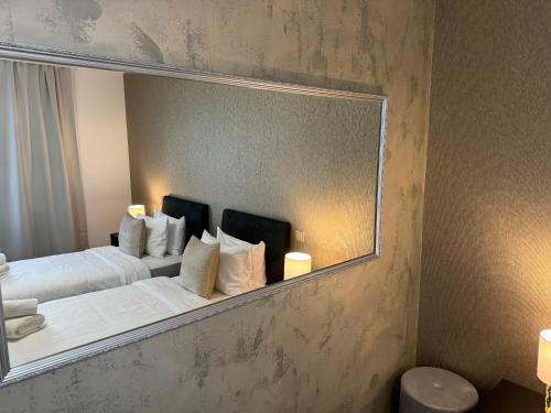 a mirror reflecting a bed in a hotel room at Penzion 4 pokoje in Prostějov